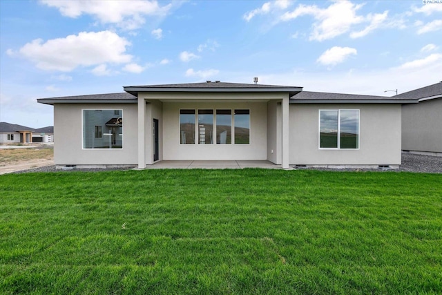 rear view of house with a yard and a patio area