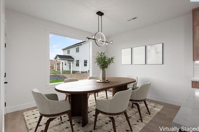 dining room with an inviting chandelier and wood-type flooring