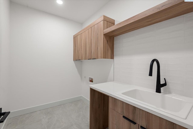 laundry room with cabinets, hookup for a washing machine, and sink