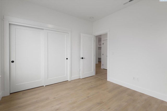 unfurnished bedroom featuring a closet and light hardwood / wood-style flooring