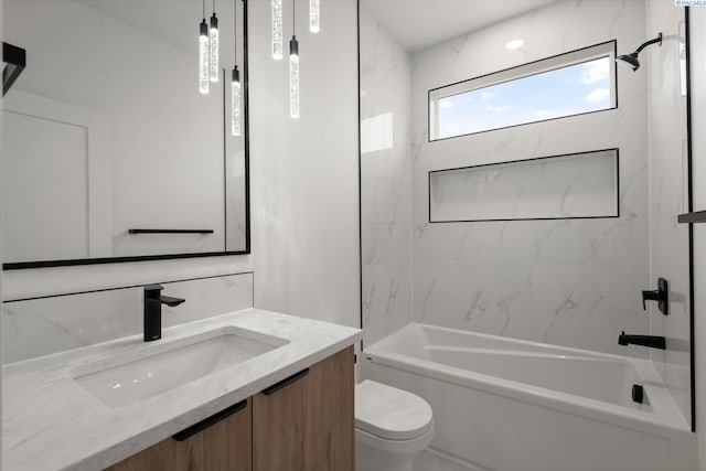 full bathroom featuring tiled shower / bath, vanity, and toilet