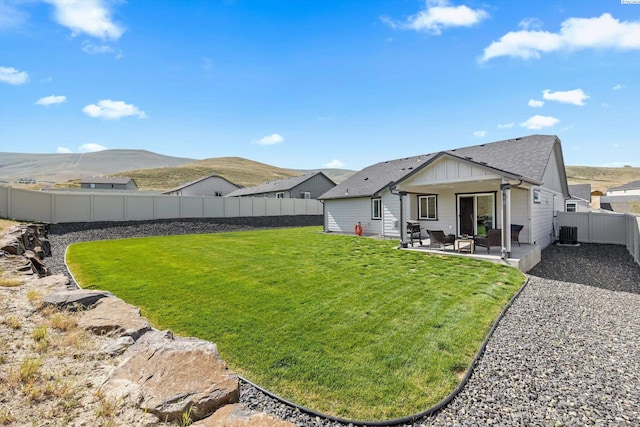 320 San Fernando Way, Prosser, WA 99350 - rear view of house with board and batten siding, a fenced backyard, cooling unit, a patio, and a yard