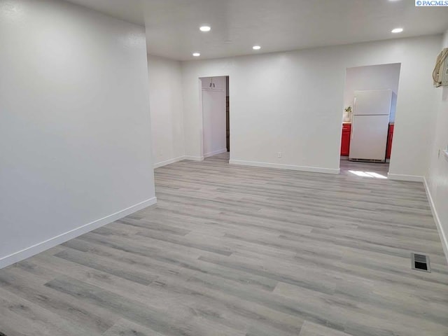 unfurnished room featuring recessed lighting, visible vents, light wood-style flooring, and baseboards