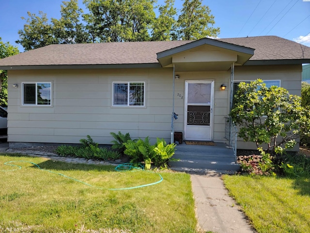 208 E 4th St, Grandview, WA 98930 - view of front of property with a front yard and a shingled roof