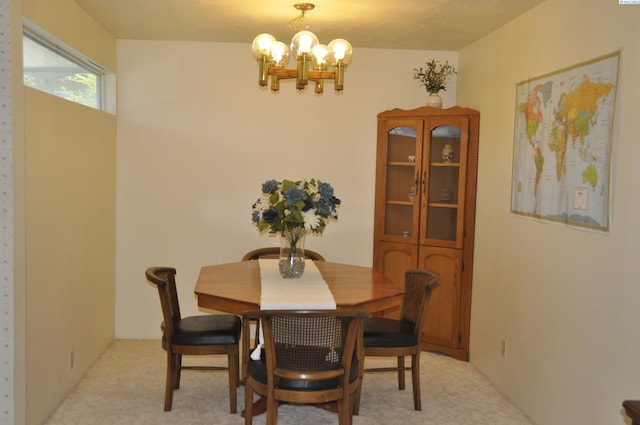dining room with a chandelier and light carpet