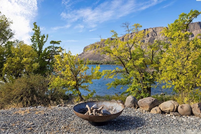 property view of water with a mountain view and a fire pit