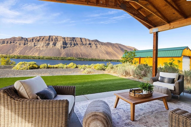 view of patio / terrace with an outdoor living space and a water and mountain view