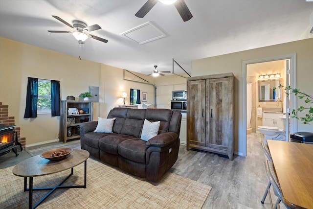 living room with a wood stove and light wood-type flooring