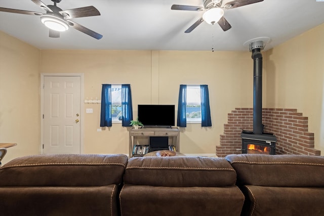living room featuring ceiling fan and a wood stove