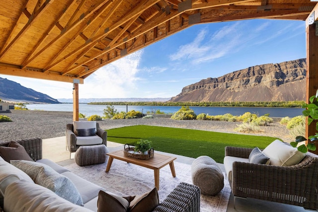 view of patio / terrace featuring a water and mountain view and outdoor lounge area