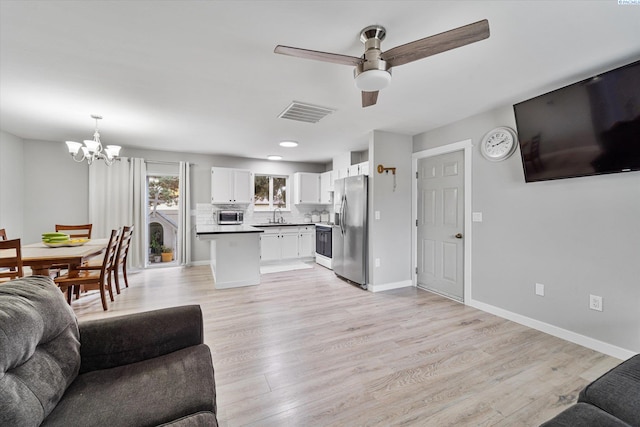 living room featuring sink, ceiling fan with notable chandelier, and light hardwood / wood-style floors