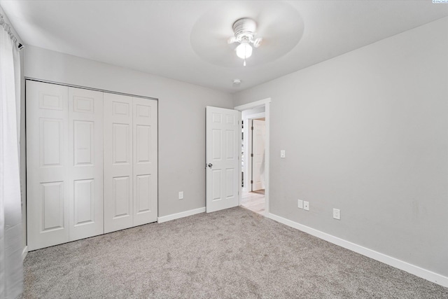 unfurnished bedroom with light colored carpet, a closet, and ceiling fan