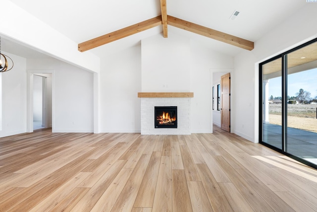 unfurnished living room with vaulted ceiling with beams, a notable chandelier, a fireplace, light wood-style floors, and baseboards