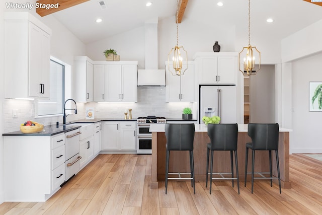 kitchen with premium appliances, a breakfast bar, light wood-style flooring, white cabinets, and beamed ceiling