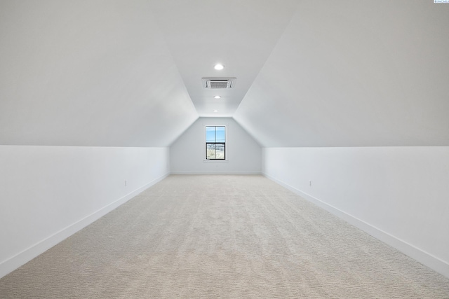 bonus room with vaulted ceiling, light colored carpet, visible vents, and baseboards