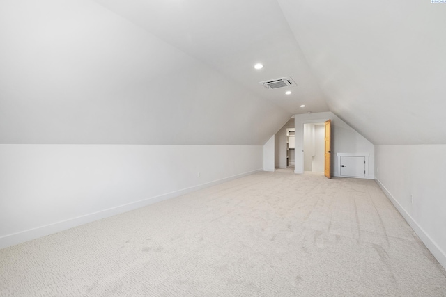 additional living space with recessed lighting, light carpet, visible vents, baseboards, and vaulted ceiling