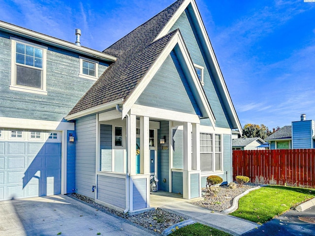 view of front of home with fence, a porch, a garage, concrete driveway, and roof with shingles