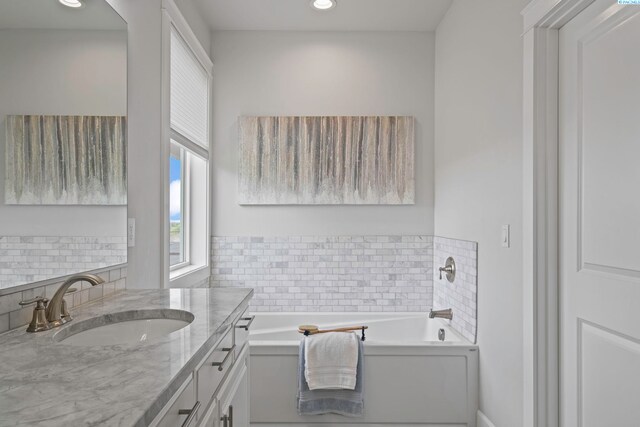 bathroom with vanity, backsplash, and a bathtub