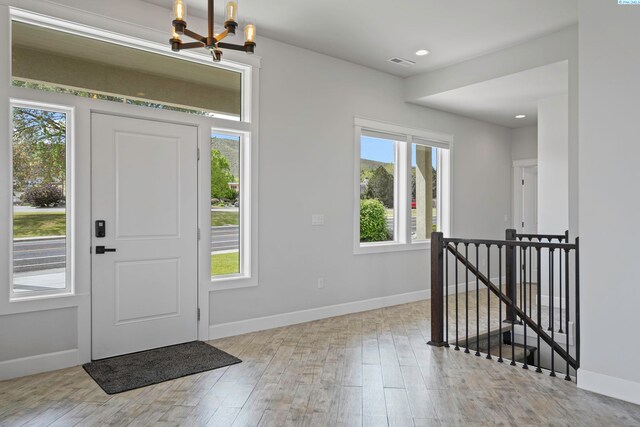 entryway featuring an inviting chandelier and light hardwood / wood-style flooring