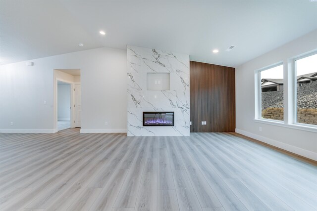 6150 W 30th Pl, Kennewick, WA 99338 - unfurnished living room featuring a premium fireplace, light wood-type flooring, baseboards, recessed lighting, and lofted ceiling