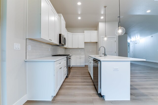 6150 W 30th Pl, Kennewick, WA 99338 - kitchen featuring appliances with stainless steel finishes, a sink, baseboards, a center island with sink, and light countertops