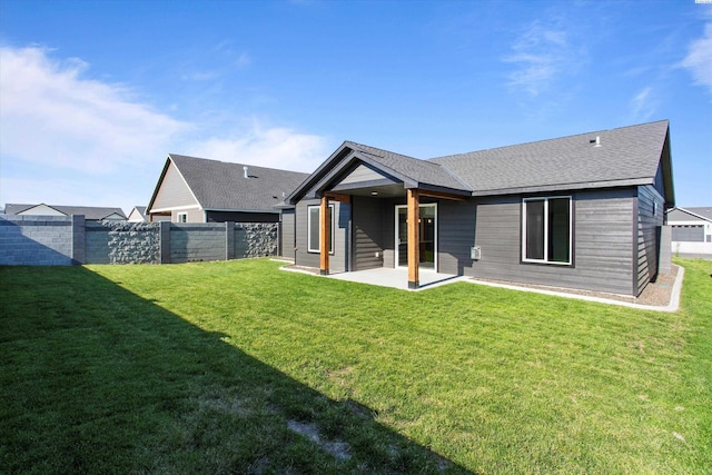 rear view of property with a yard and a patio area