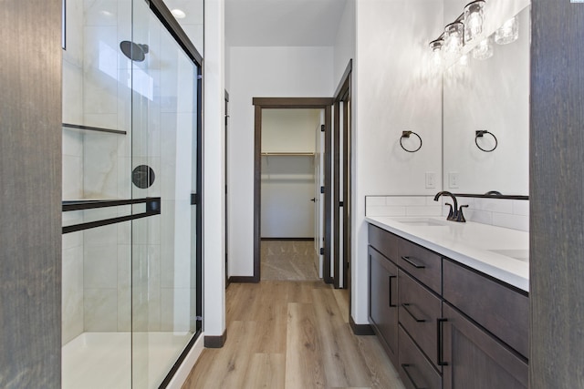 bathroom featuring vanity, hardwood / wood-style floors, and a shower with shower door