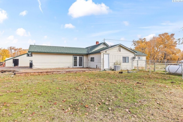 back of house featuring cooling unit, a lawn, and a patio