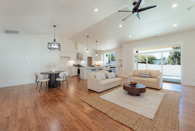 living room with lofted ceiling, light hardwood / wood-style floors, and ceiling fan