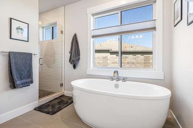 full bathroom with a stall shower, baseboards, a soaking tub, and tile patterned flooring