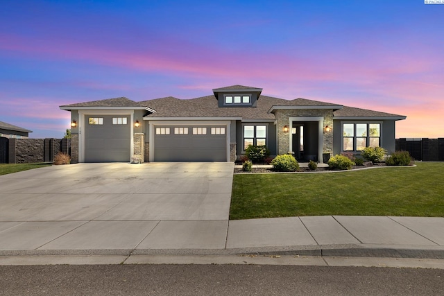 prairie-style home with a garage, stone siding, concrete driveway, and stucco siding