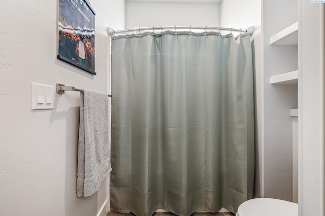 bathroom with a shower with curtain and toilet