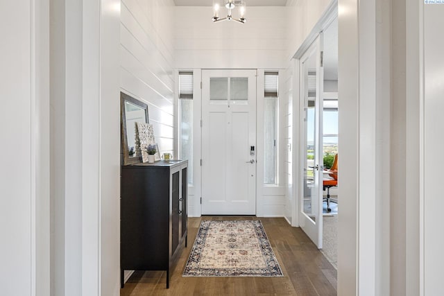 entrance foyer with wood finished floors and a chandelier
