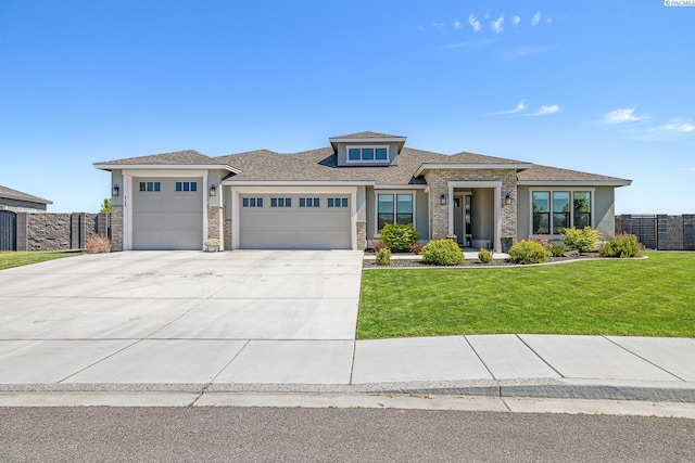 prairie-style house with stone siding, a garage, stucco siding, a front yard, and concrete driveway