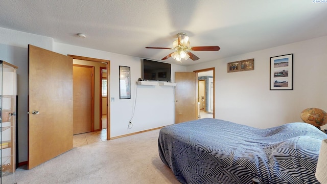 carpeted bedroom featuring ceiling fan and a textured ceiling