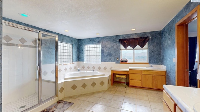 bathroom with vanity, tile patterned flooring, plus walk in shower, and a textured ceiling