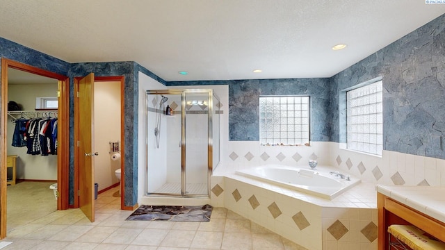 full bathroom with tile patterned floors, toilet, separate shower and tub, a textured ceiling, and vanity