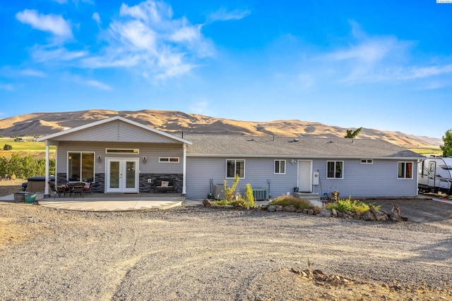 back of house featuring a mountain view, central AC unit, a patio area, and french doors