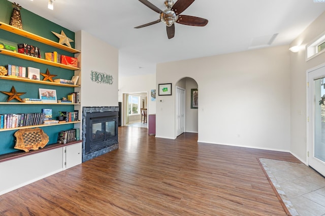 living room featuring a tiled fireplace, hardwood / wood-style flooring, and ceiling fan