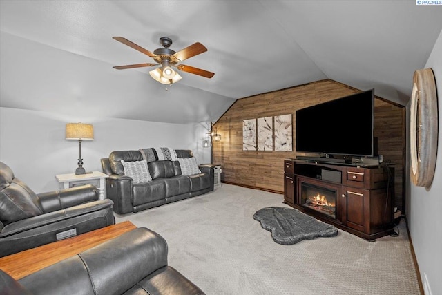 404 S Georgia St, Kennewick, WA 99338 - living area featuring wooden walls, light colored carpet, a glass covered fireplace, a ceiling fan, and lofted ceiling