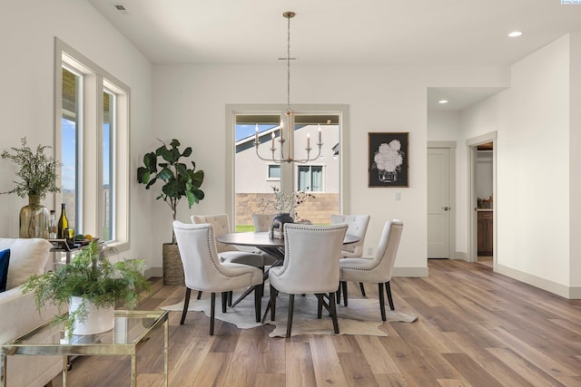 dining space featuring recessed lighting, baseboards, a notable chandelier, and light wood finished floors