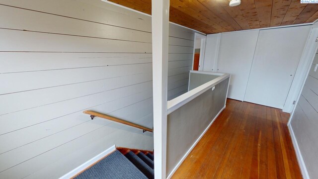 hall featuring dark wood-type flooring and wooden ceiling