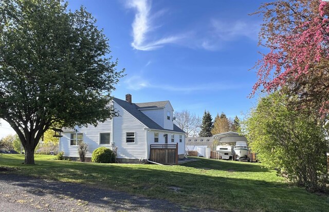 view of side of home featuring a carport and a yard