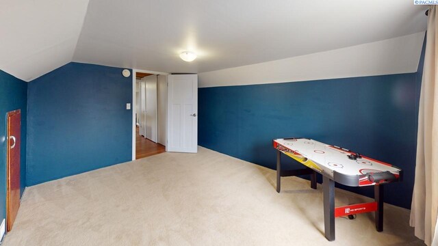 playroom featuring vaulted ceiling and carpet flooring