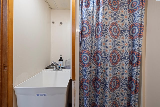 bathroom featuring a shower with shower curtain and a sink