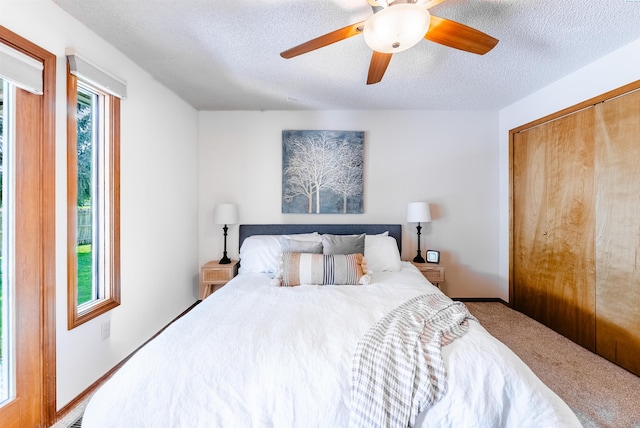 carpeted bedroom featuring a textured ceiling, ceiling fan, and a closet