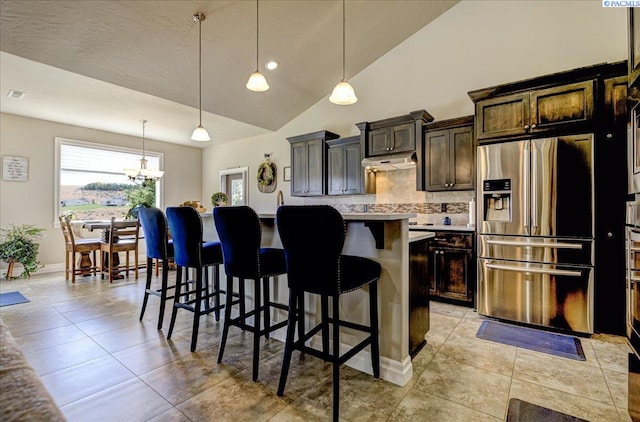 87021 Summit View Dr, Kennewick, WA 99338 - kitchen featuring stainless steel refrigerator with ice dispenser, a breakfast bar, backsplash, a kitchen island, and light tile patterned floors