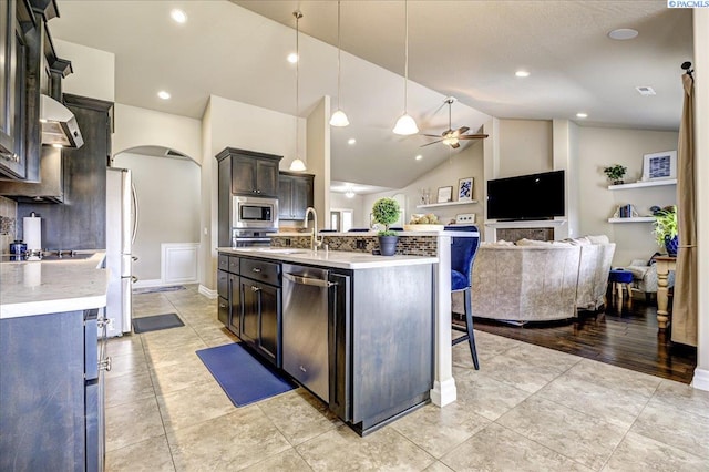 87021 Summit View Dr, Kennewick, WA 99338 - kitchen featuring appliances with stainless steel finishes, arched walkways, a ceiling fan, light countertops, and high vaulted ceiling
