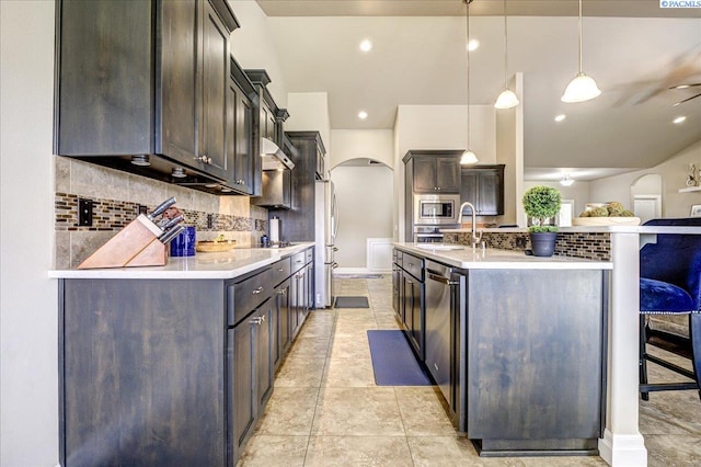87021 Summit View Dr, Kennewick, WA 99338 - kitchen with arched walkways, appliances with stainless steel finishes, backsplash, light countertops, and dark brown cabinetry