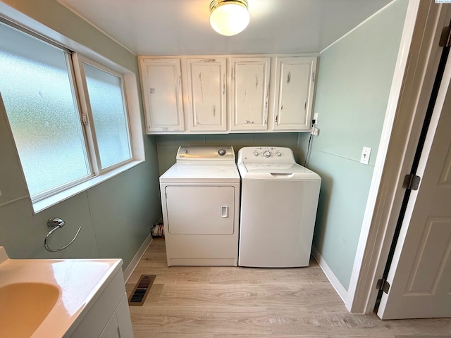 419 W A Ave, Colfax, WA 99111 - washroom with washing machine and clothes dryer, cabinet space, light wood-style floors, and baseboards